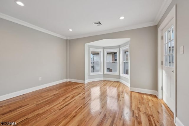 empty room featuring crown molding and light hardwood / wood-style floors