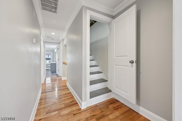 hall with crown molding and light hardwood / wood-style floors