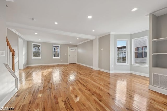 unfurnished living room with crown molding and light hardwood / wood-style floors