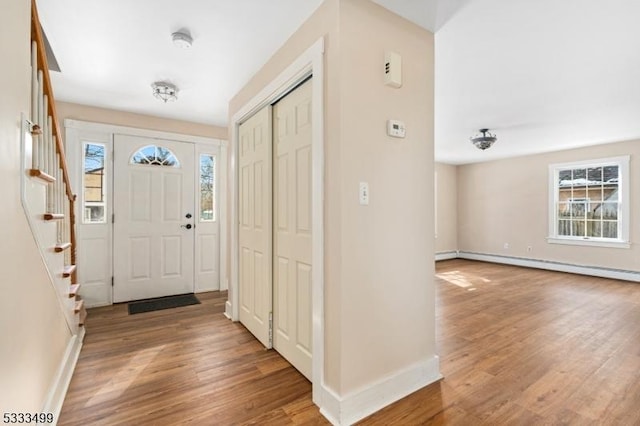 entryway featuring hardwood / wood-style flooring, a baseboard heating unit, and a healthy amount of sunlight