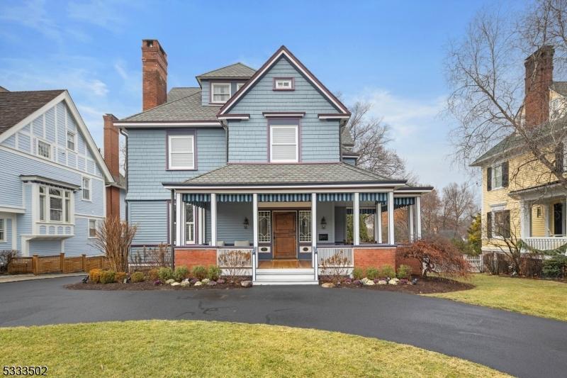 victorian-style house with a front yard and a porch