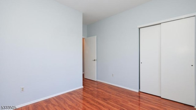 unfurnished bedroom featuring hardwood / wood-style flooring and a closet