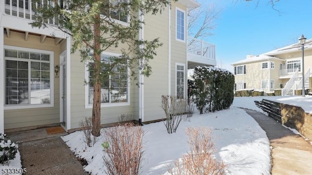 view of snow covered exterior featuring a balcony