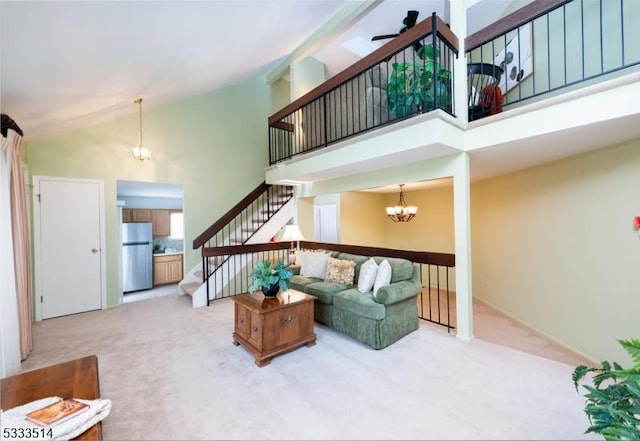 living room with light carpet, an inviting chandelier, and a towering ceiling