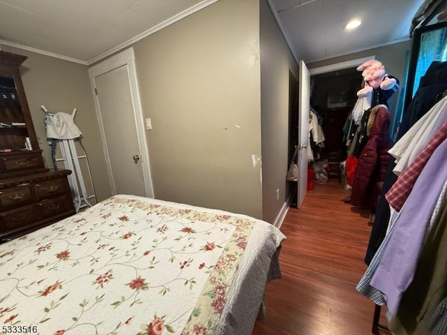 bedroom with a closet, dark wood-type flooring, and crown molding