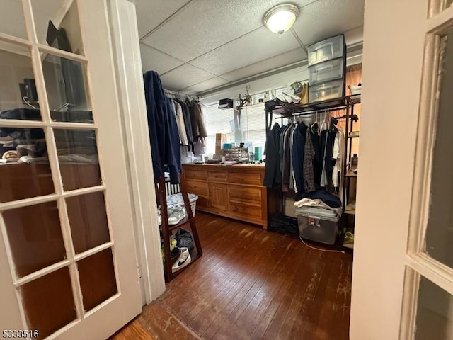 walk in closet with a drop ceiling and dark hardwood / wood-style floors