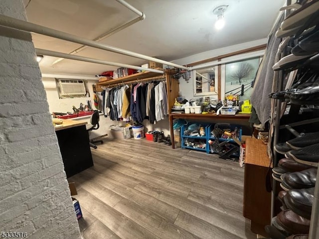 spacious closet featuring a wall mounted AC and wood-type flooring