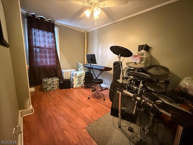 office featuring ceiling fan, wood-type flooring, radiator heating unit, and ornamental molding