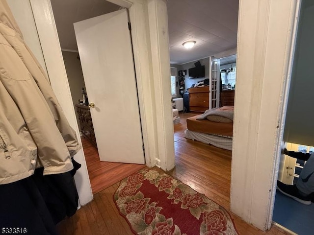 hallway with crown molding and wood-type flooring