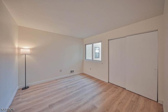 unfurnished bedroom with a closet and light hardwood / wood-style flooring