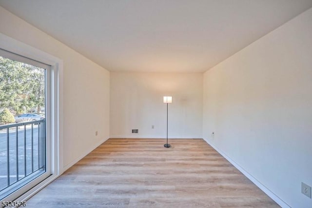 clothes washing area with light hardwood / wood-style floors