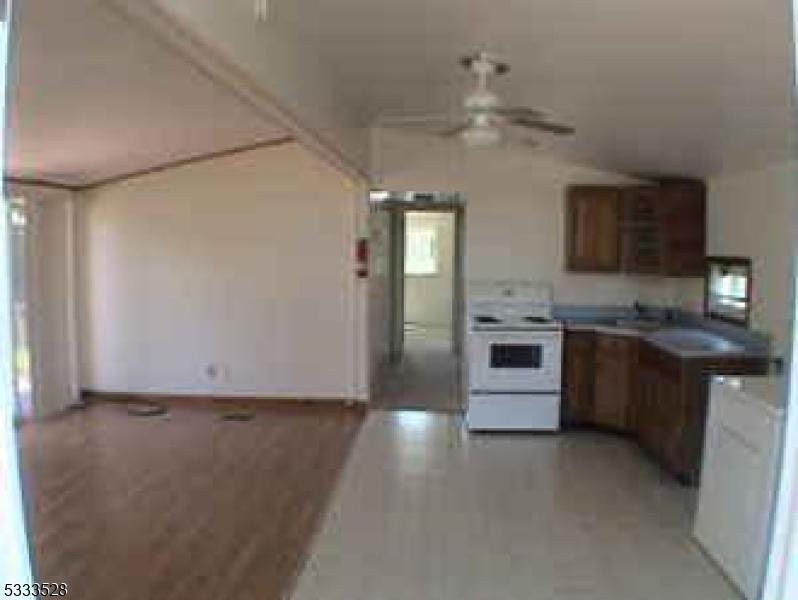 kitchen featuring ceiling fan, white electric stove, and refrigerator