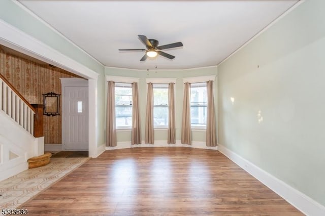 entryway featuring ceiling fan, ornamental molding, and light hardwood / wood-style floors