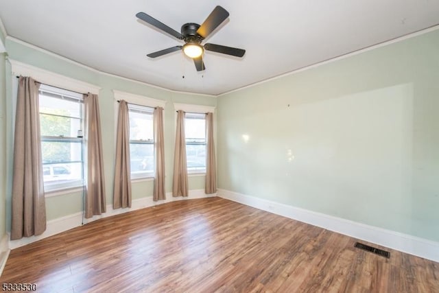 unfurnished room featuring ceiling fan, wood-type flooring, and crown molding