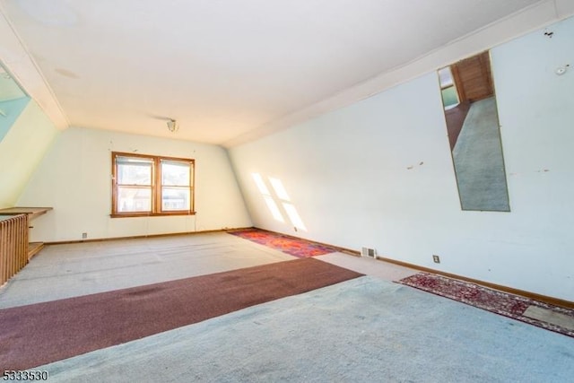 additional living space with vaulted ceiling and light colored carpet