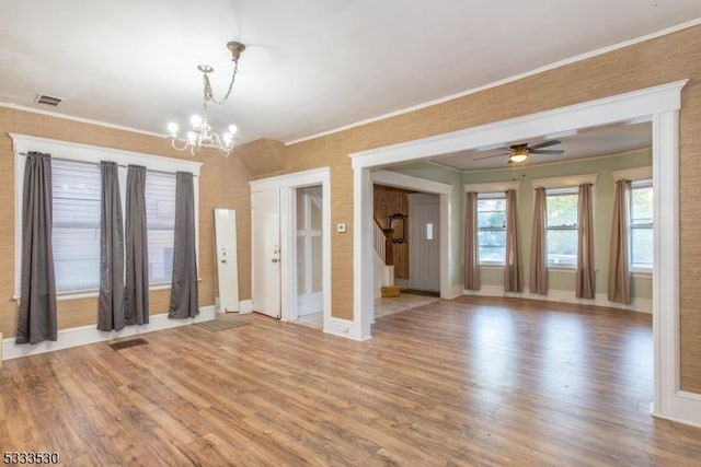 spare room featuring hardwood / wood-style flooring, ornamental molding, and ceiling fan with notable chandelier