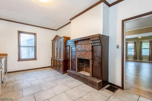 unfurnished living room featuring a brick fireplace, plenty of natural light, light tile patterned floors, and ornamental molding