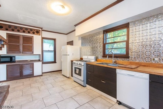 kitchen featuring crown molding, wood counters, sink, and white appliances