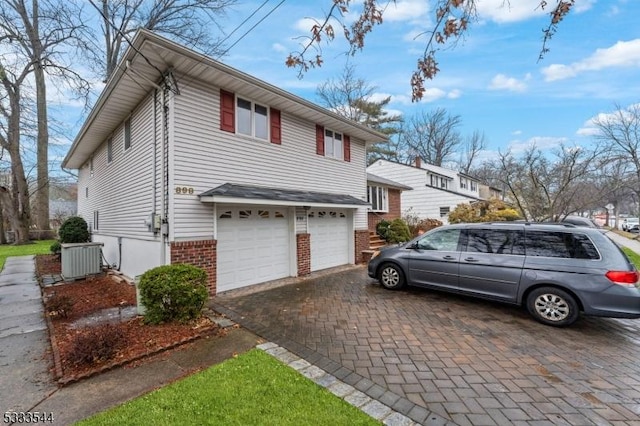 view of home's exterior with a garage and central AC unit