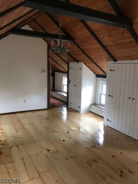 bonus room featuring wood ceiling, light hardwood / wood-style flooring, and vaulted ceiling with beams