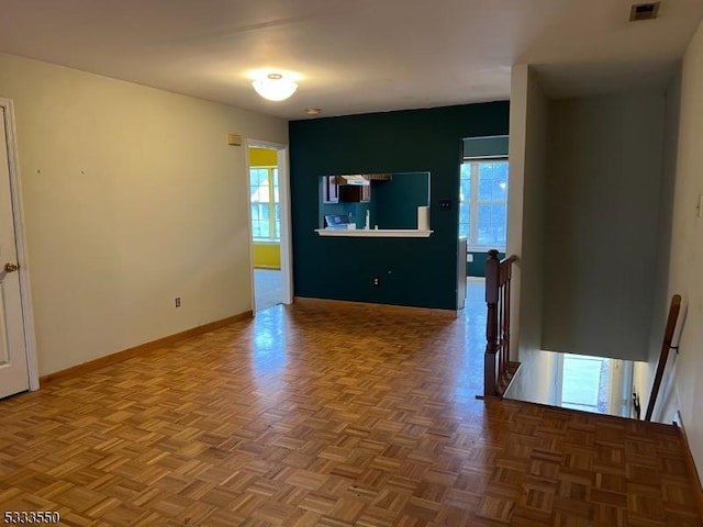 empty room with plenty of natural light and parquet flooring