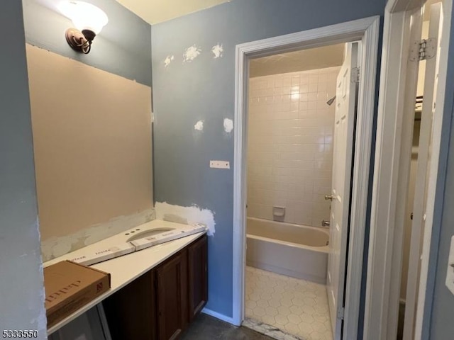 bathroom featuring tiled shower / bath combo and vanity