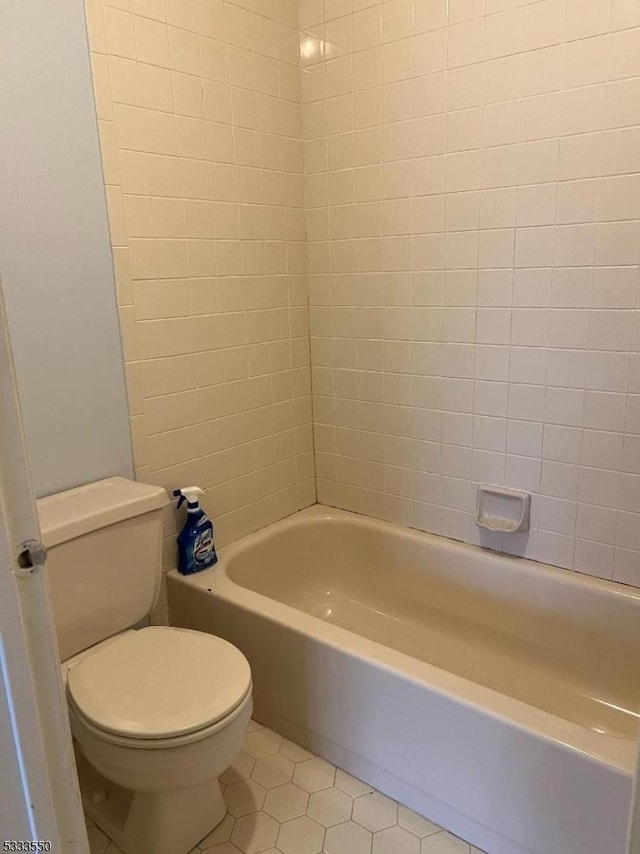 bathroom featuring shower / bathtub combination, tile patterned floors, and toilet