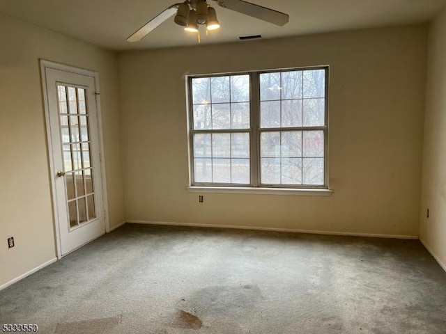 carpeted empty room featuring ceiling fan and a wealth of natural light