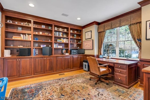 home office featuring light wood-type flooring and ornamental molding