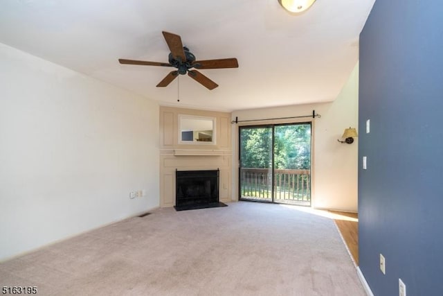 unfurnished living room with light colored carpet and ceiling fan