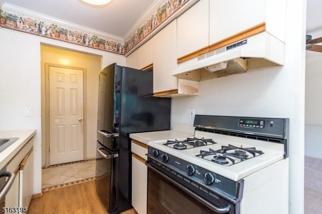 kitchen with black refrigerator, crown molding, white cabinets, light wood-type flooring, and white range with gas stovetop