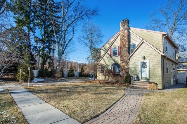 view of side of home featuring a chimney and a lawn