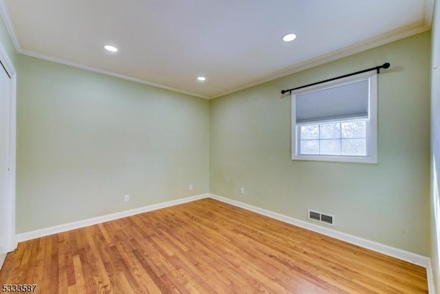 empty room with crown molding and light hardwood / wood-style flooring