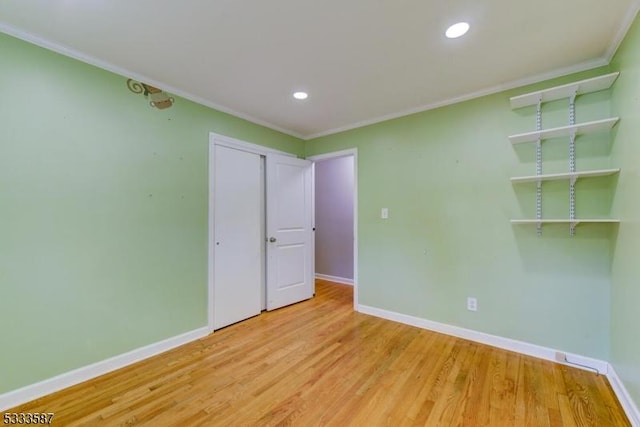 unfurnished bedroom with a closet, ornamental molding, and light hardwood / wood-style flooring