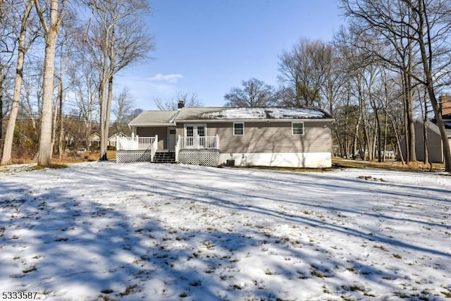 snow covered rear of property featuring a wooden deck