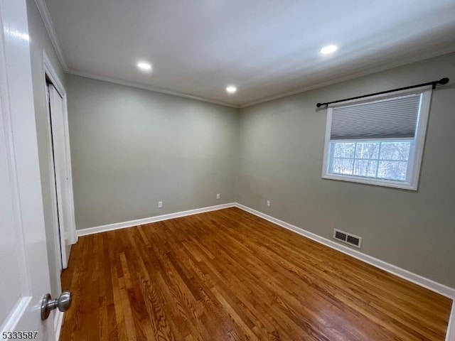 unfurnished bedroom with hardwood / wood-style floors, ornamental molding, and a closet