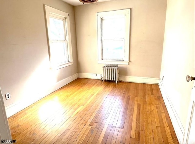 unfurnished room with light hardwood / wood-style floors and radiator