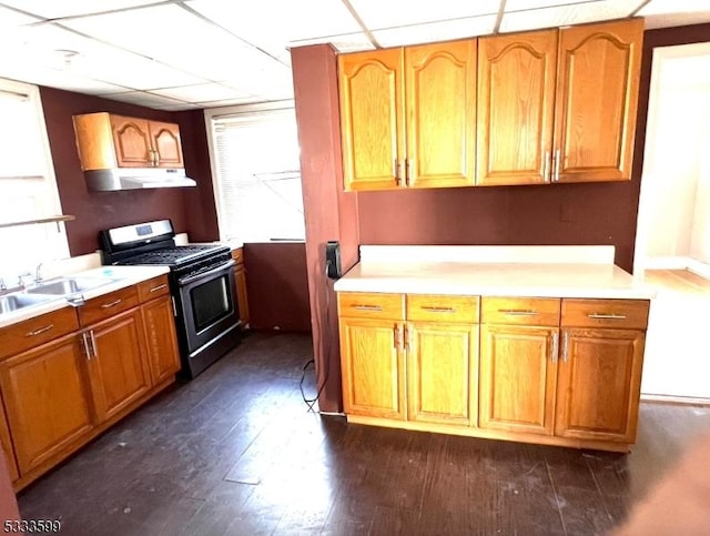 kitchen featuring sink, a paneled ceiling, stainless steel gas stove, and dark hardwood / wood-style flooring