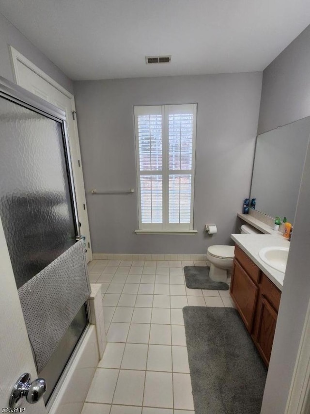 full bathroom with toilet, vanity, tile patterned flooring, and bath / shower combo with glass door