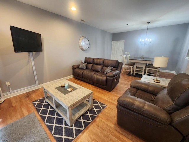 living room with wood-type flooring and a chandelier