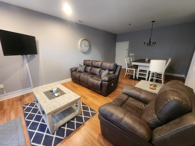 living room with an inviting chandelier and hardwood / wood-style flooring