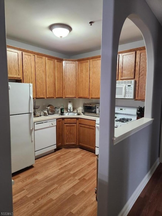 kitchen featuring light hardwood / wood-style floors, sink, and white appliances