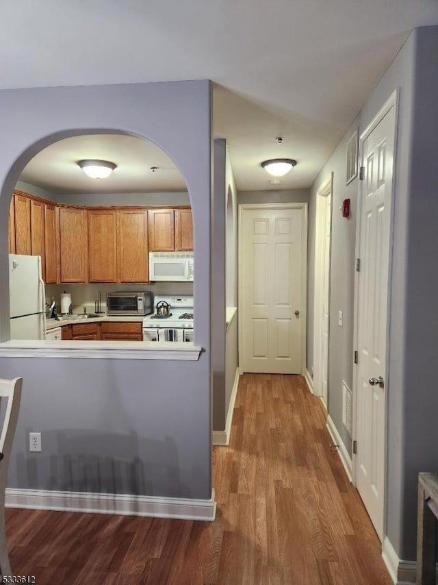 kitchen with wood-type flooring and white appliances