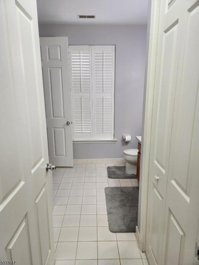 bathroom with toilet, tile patterned flooring, and vanity