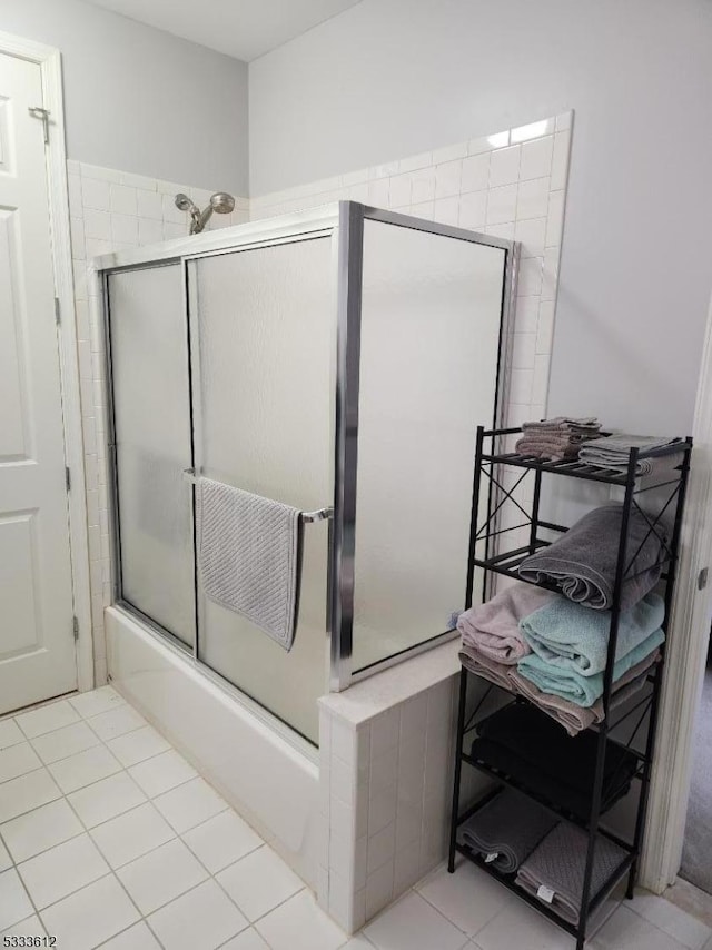 bathroom with combined bath / shower with glass door and tile patterned flooring