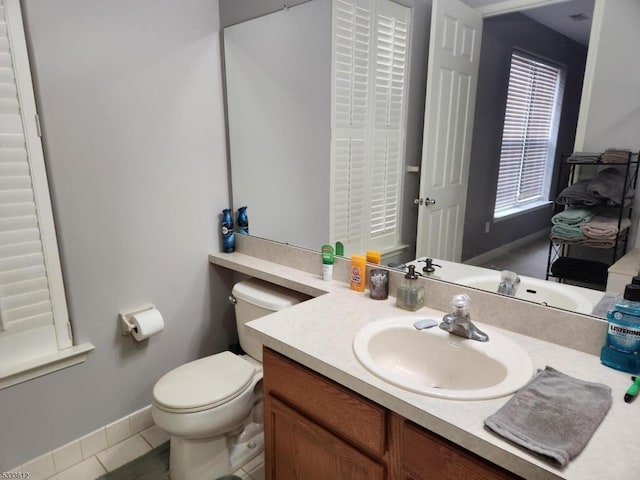 bathroom with toilet, tile patterned floors, and vanity