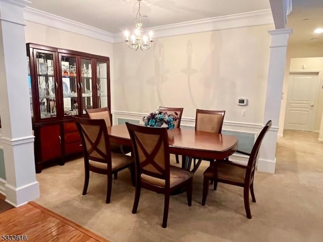 dining room with ornamental molding, ornate columns, and an inviting chandelier