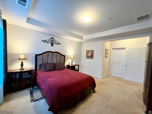 bedroom with a raised ceiling, crown molding, and light carpet