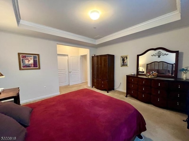 bedroom featuring ornamental molding, light carpet, and a tray ceiling