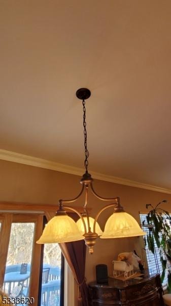 interior details with ornamental molding and a chandelier